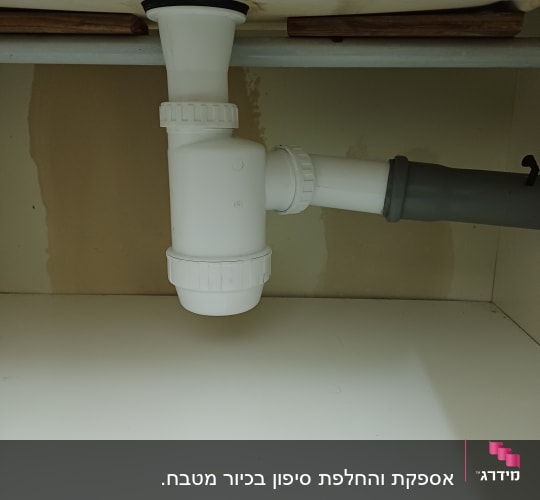 צנרת פלסטיק לבנה מתחת לכיור עם חיבורים